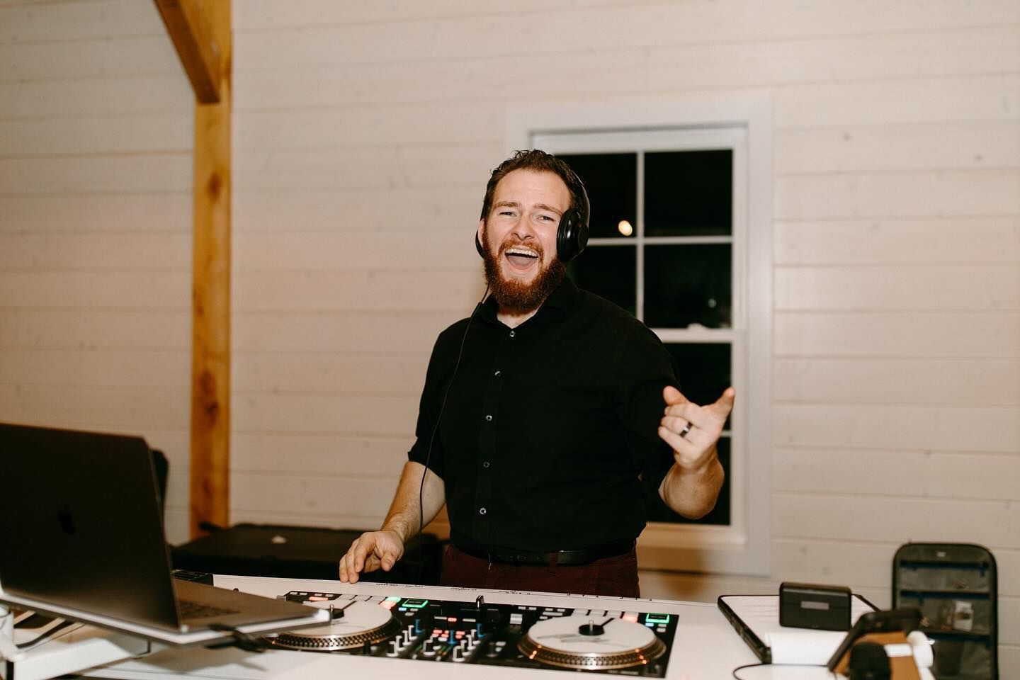 Cole Coleman laughing behind the decks at a wedding reception