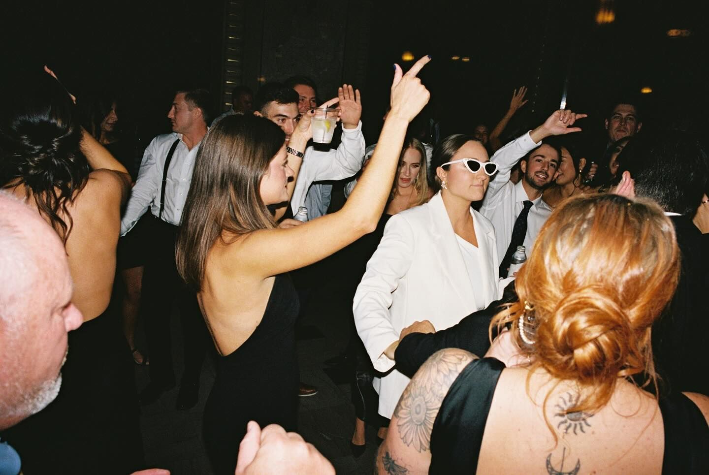 Wedding guests dancing with their hands in the air at a reception